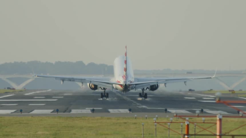 A jet lands on an airport landing strip