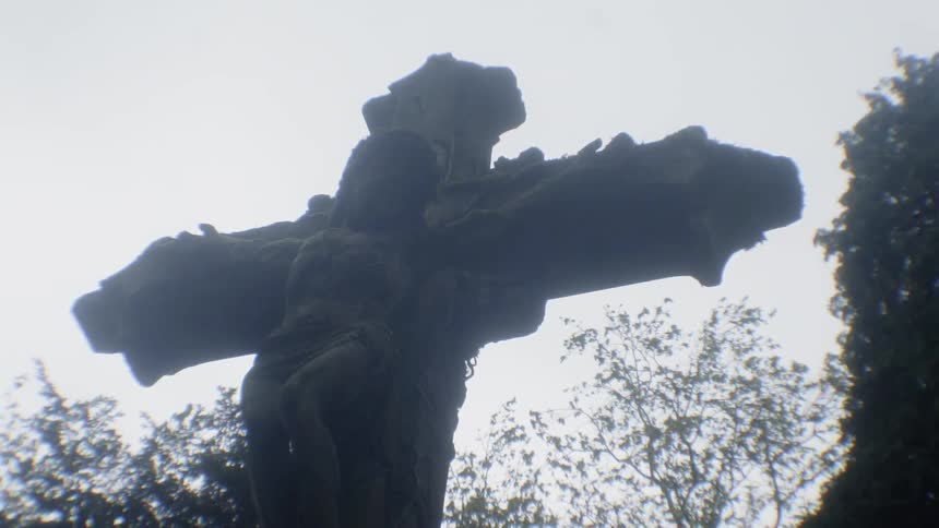 A statue of a cross is outside