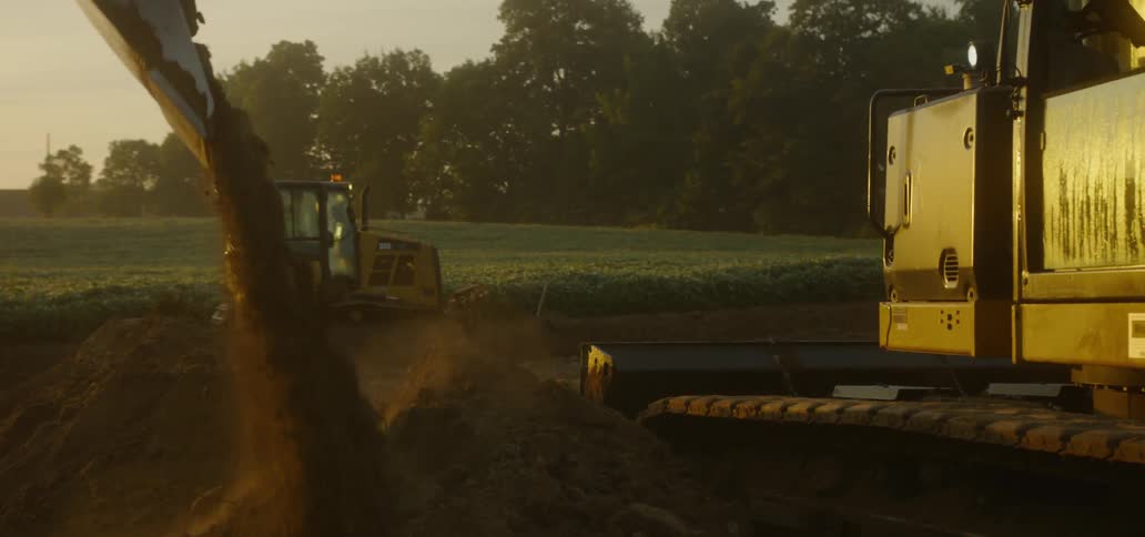 Bulldozer and Excavator Moving Dirt at Construction site