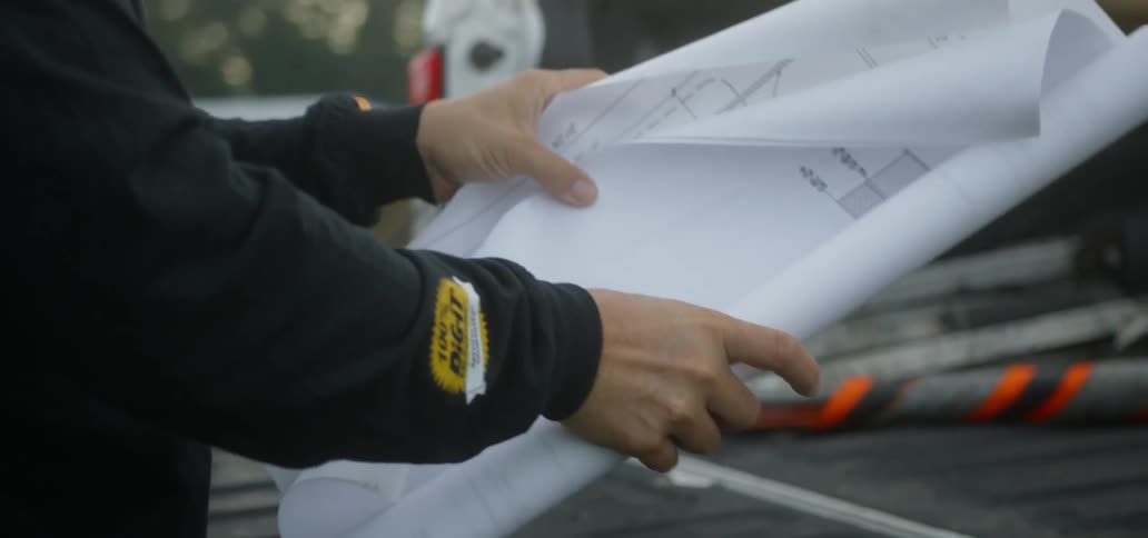 Person unrolls blueprints