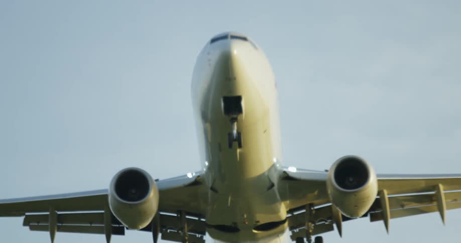 A plane comes in for a landing in the cloudy sky