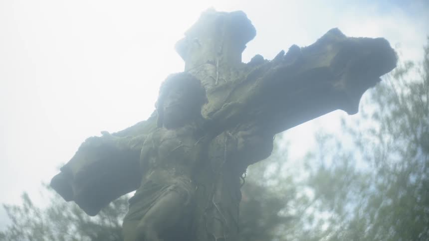 Statue of jesus on the cross with trees in background