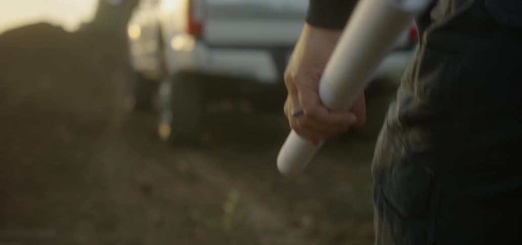 Man holding folder up poster walks to truck