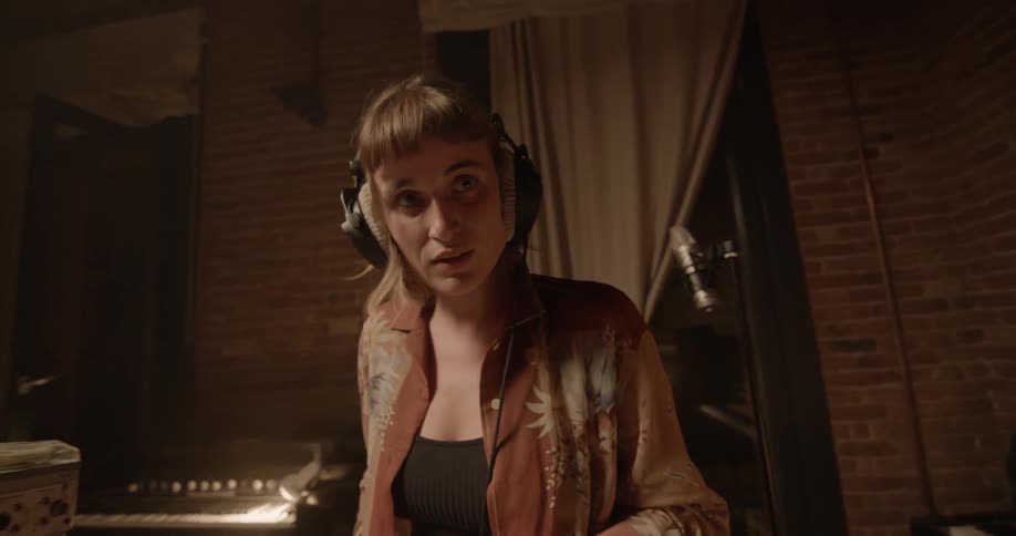 A woman is listening with headphones as she plays