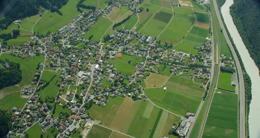 Houses dot a large area of grassy plains