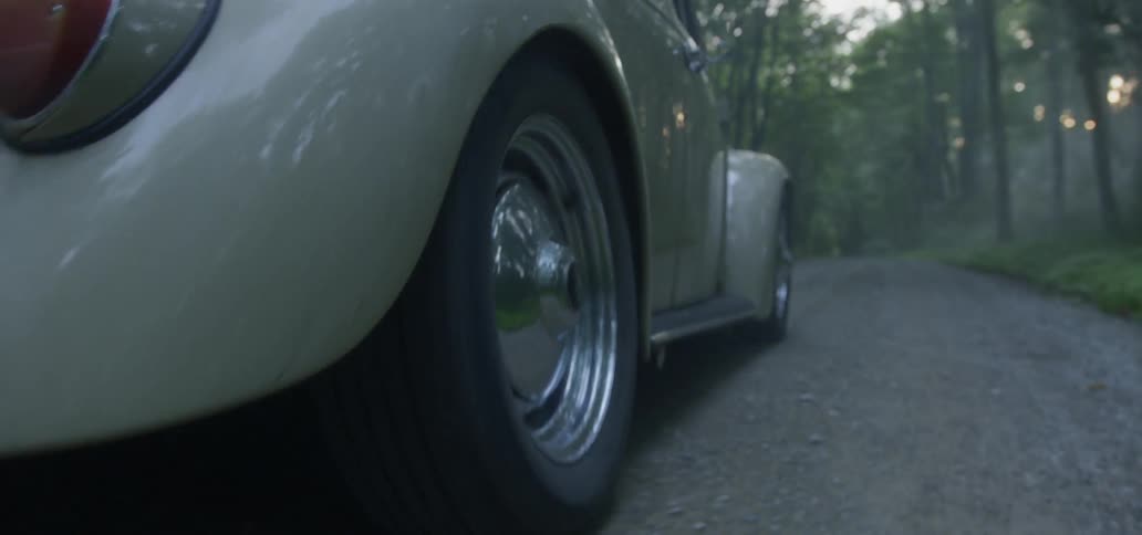 Volkswagen beetle driving down a rocky road