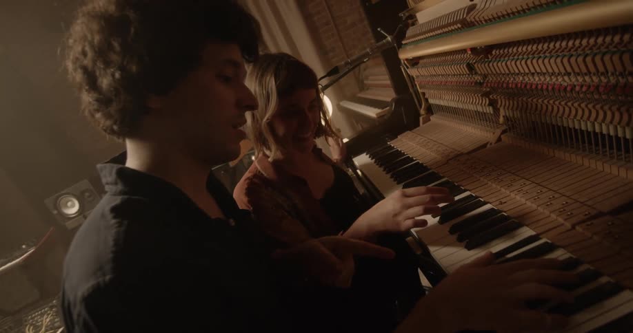 Young man and woman play piano