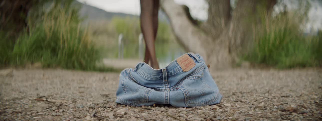 A person drops their shorts and walks towards water