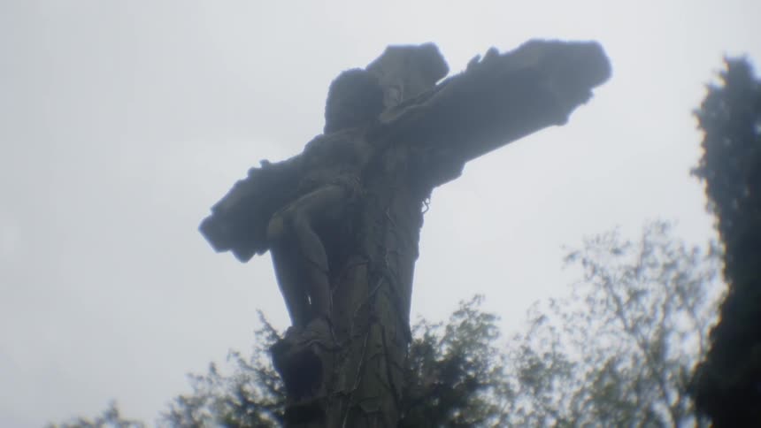 Jesus on the cross next to some trees