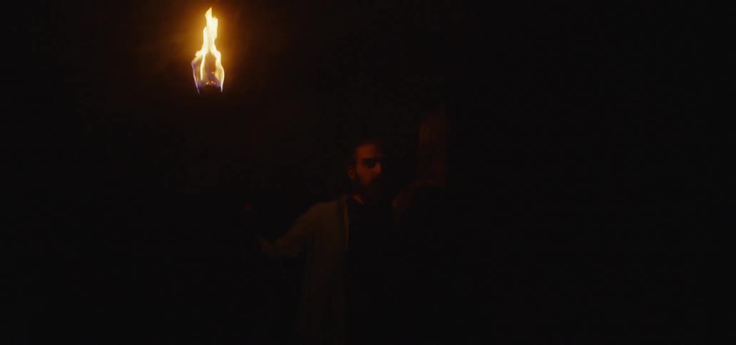 Man holds torch as only source of light