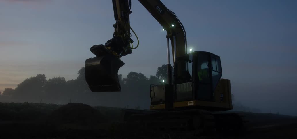A person is operating a crane and moving dirt