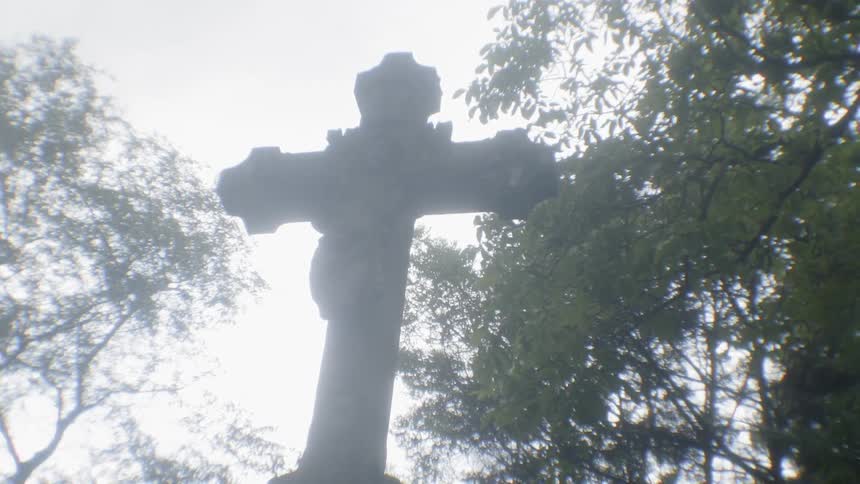 A statue of a cross is outside
