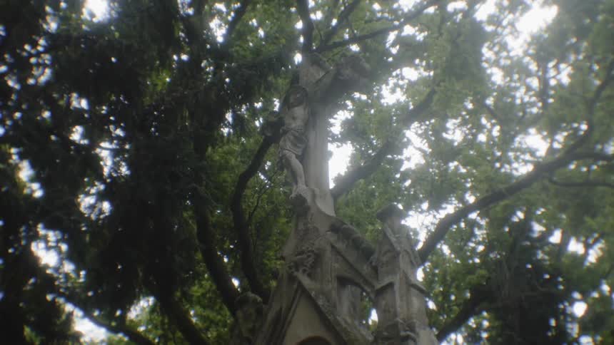 A statue of christ on the cross with trees in the background