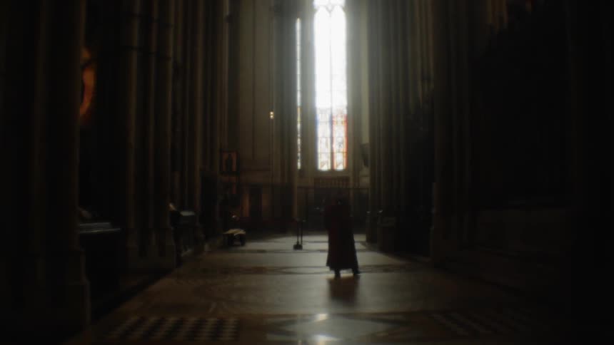 A person stands at the end of the dark hall
