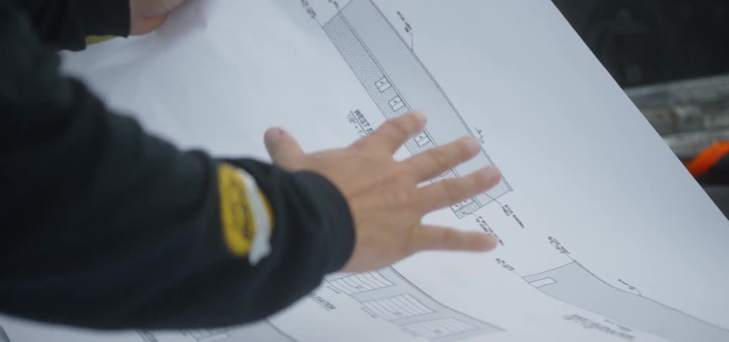 A construction worker looks over technical drawings