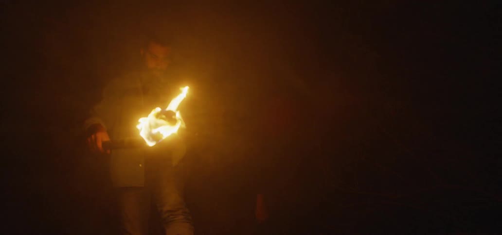 People walk around in a cave with a torch