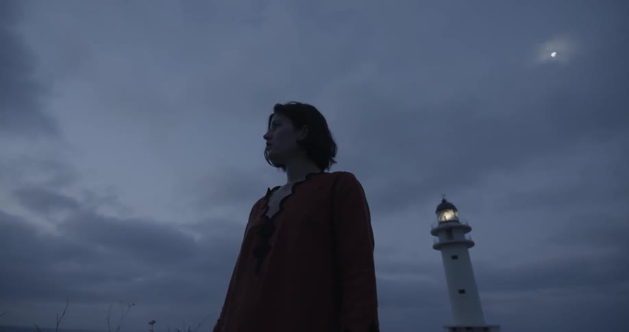 A woman is standing outside at dusk