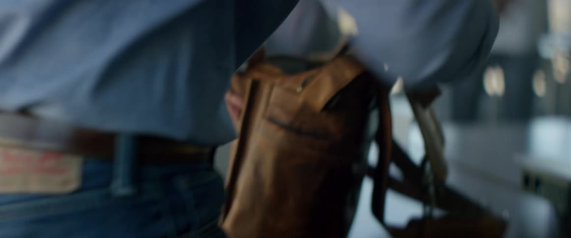 A man packing things into a brown satchel