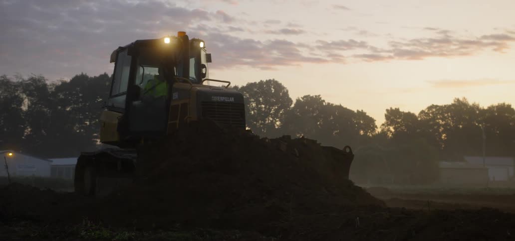Tractor moving dirt on a cold morning