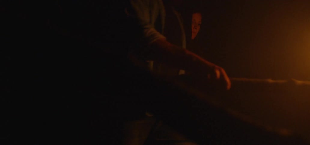 Two people are walking holding torches with fire