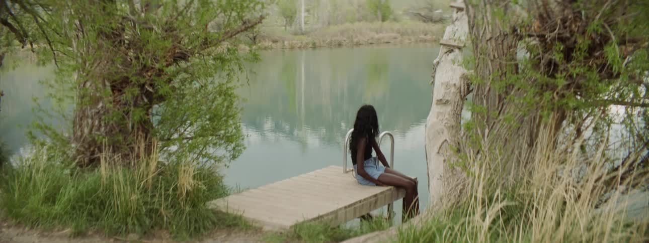 Woman sits alone on a small pier