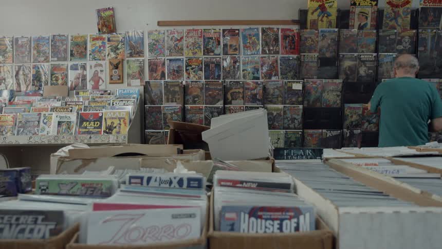 View of a comic book store and a man looking at the shelves