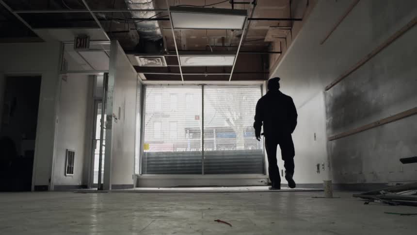 Man walking in a building towards a window