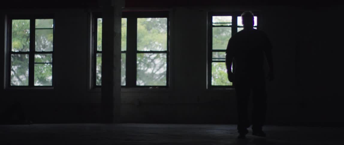 A man walks in front of a window