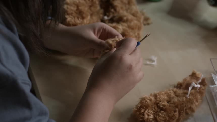 A woman making a stuffed animal