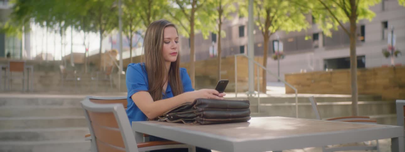 A woman types on her phone