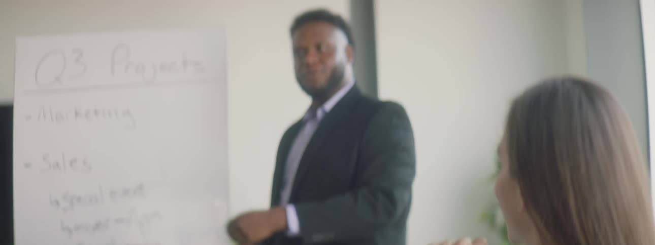 A woman sitting in a meeting and listening to the presenter