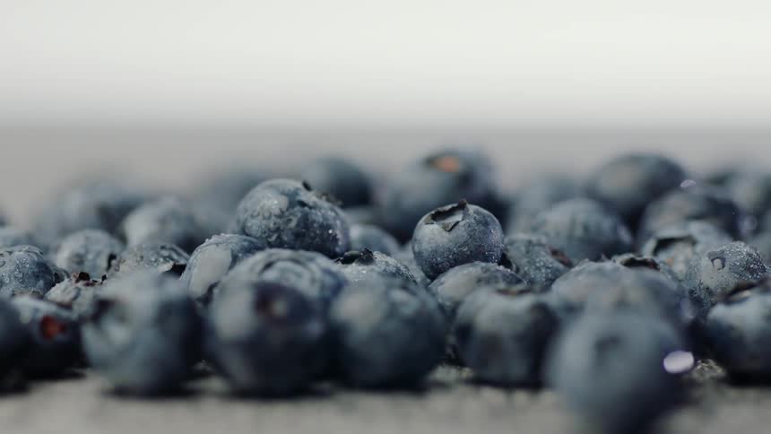 Blueberries on a surface being thrown up by an impact