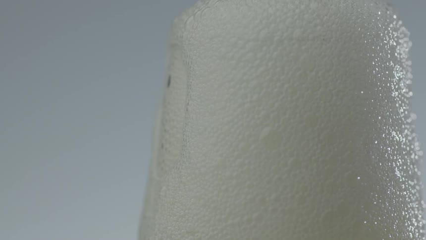 Clear bubbling liquid overflows out of a champagne glass