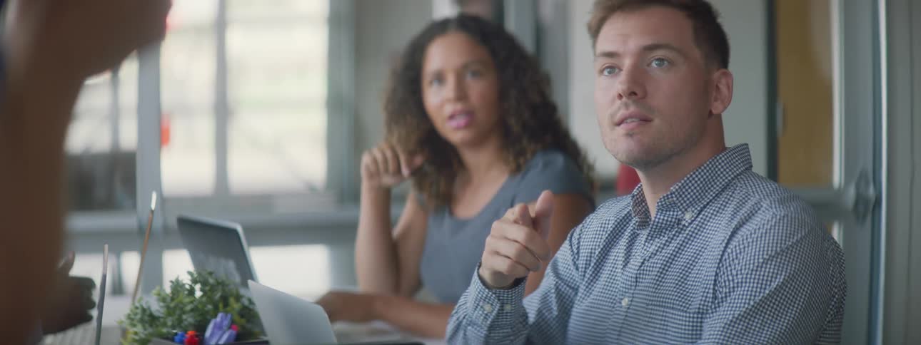 A woman laughs while the man sitting next to her talks