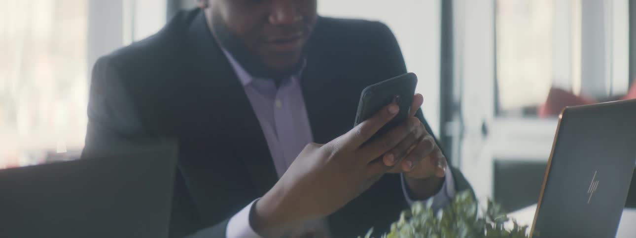 A man uses his phone at the table