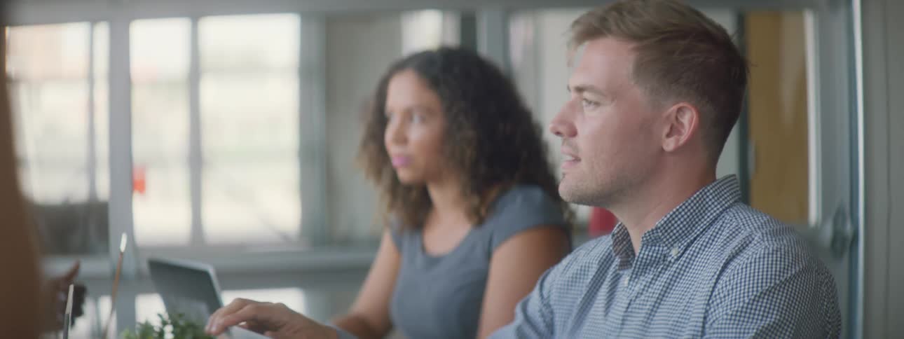 A man and woman are sitting down and talking to someone
