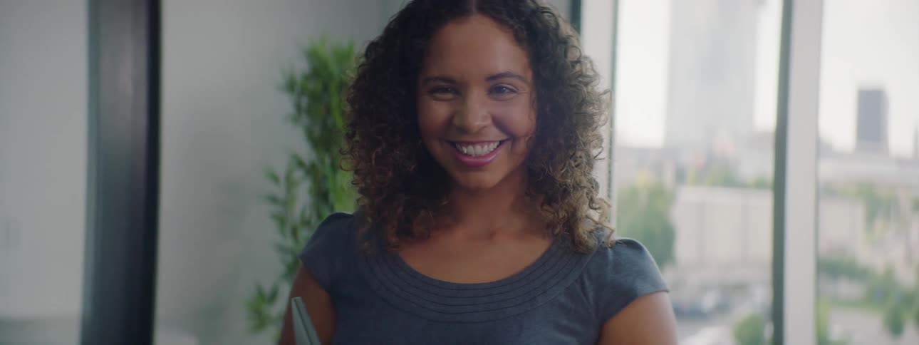 Smiling woman looks out the window of an office