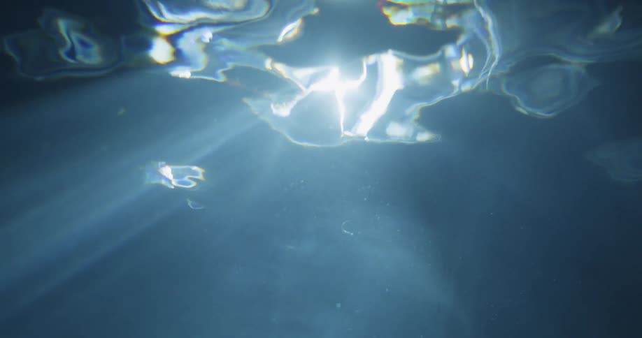 Light shines through the surface of rippling water