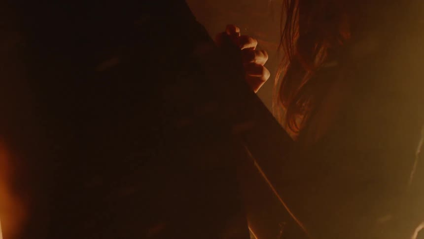 Man and woman are slow dancing near bonfire at night