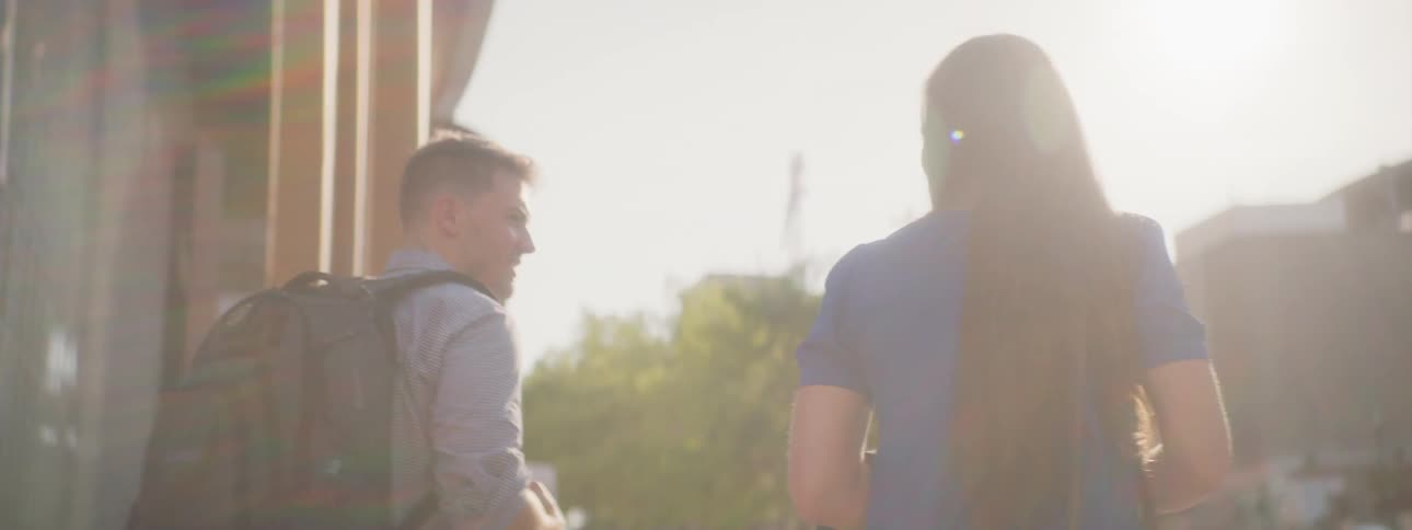 A woman and man are walking outside together