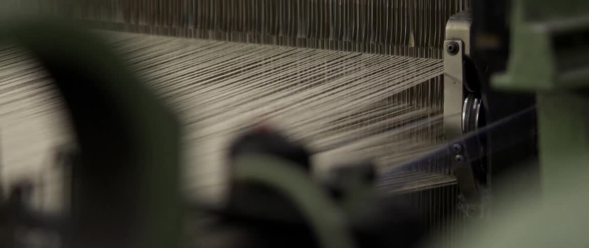 An industrial loom creates fabric