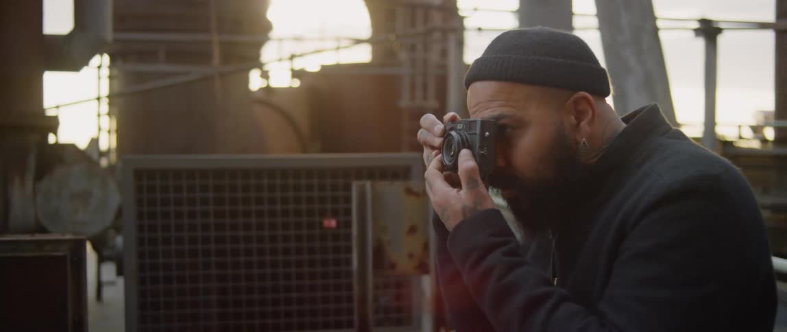 A man takes a photograph at sunset