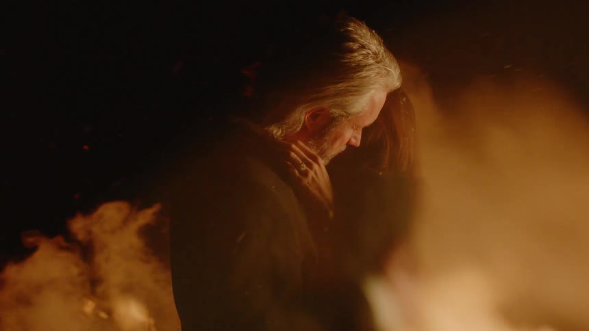 Man and woman are hugging by a fire