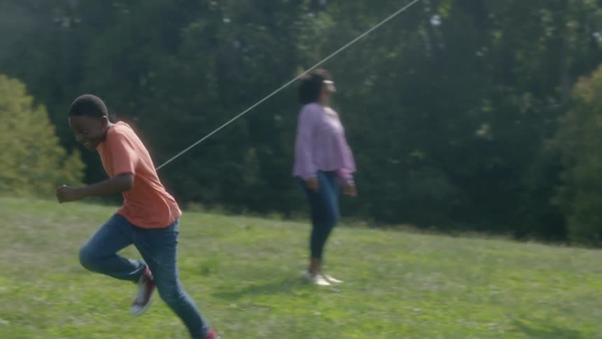 A family play outside with a kite