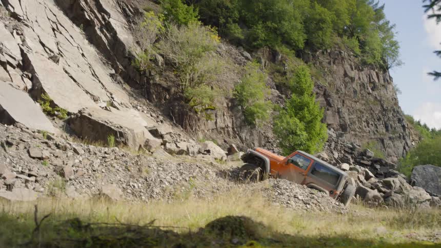 A jeep driving straight for a rocky hillside