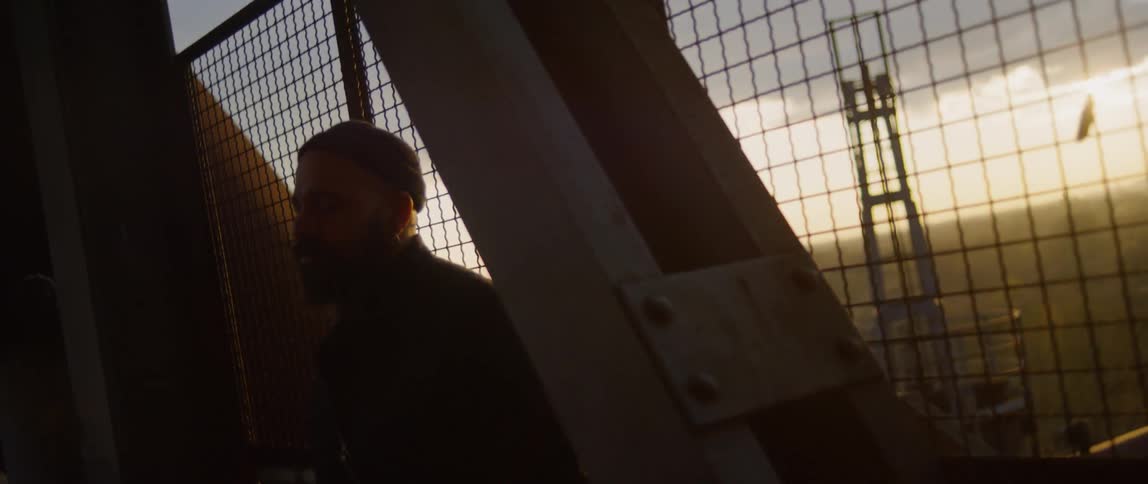 A man standing in front of a fence