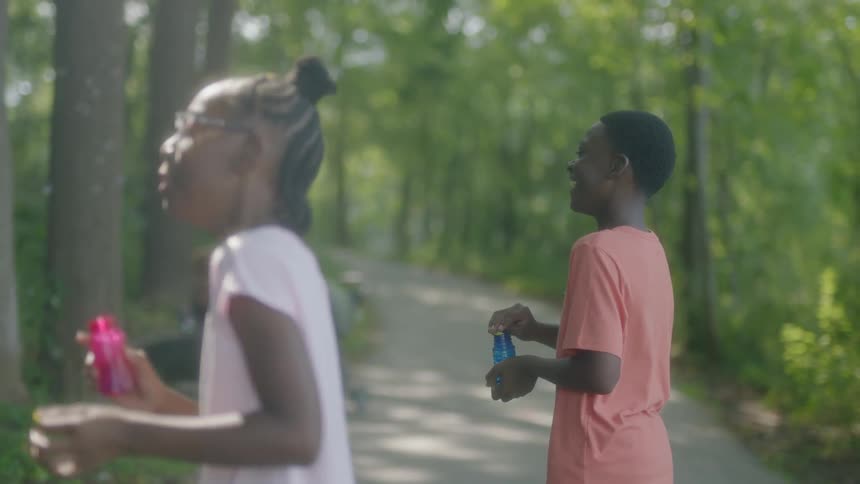 Two young adults blowing bubbles and laughing