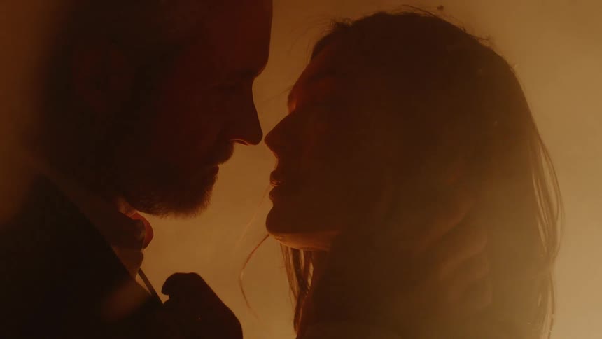 Man and woman are kissing near bonfire in the night