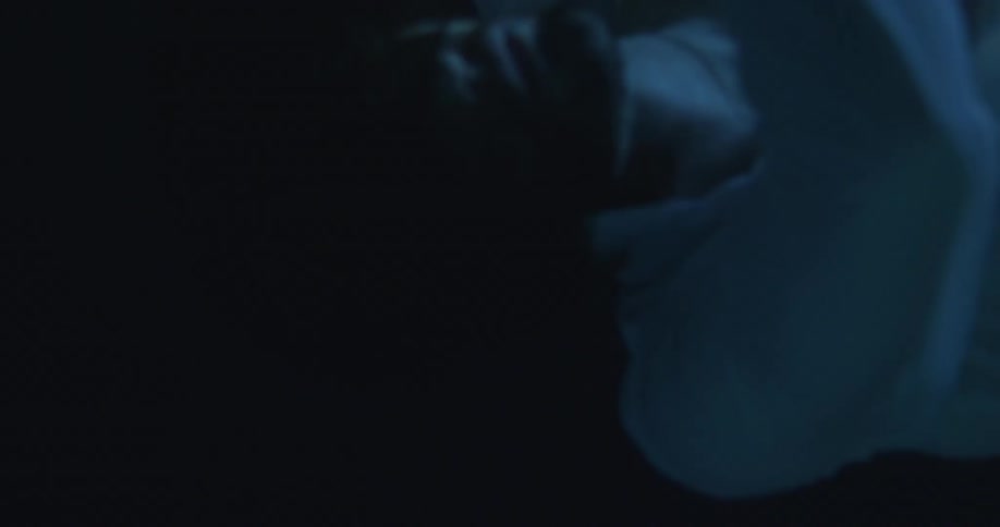 A man blowing air bubbles as he sinks down underwater