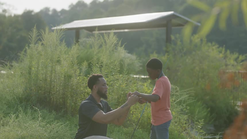 Man fixes a fishing pole for a child